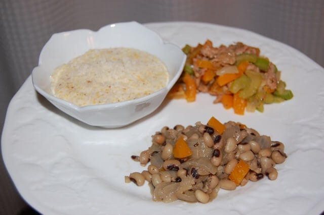 Plate of black-eyed peas for New Year's Day with a side of polenta and homemade stuffing. 