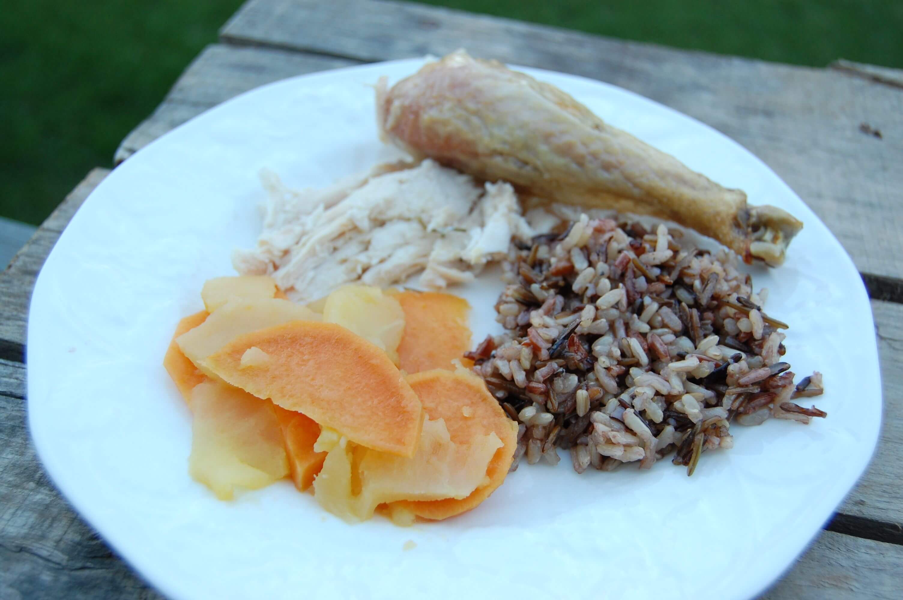 A plate of roasted chicken, wild rice, and sautéed sweet potatoes/apples. 