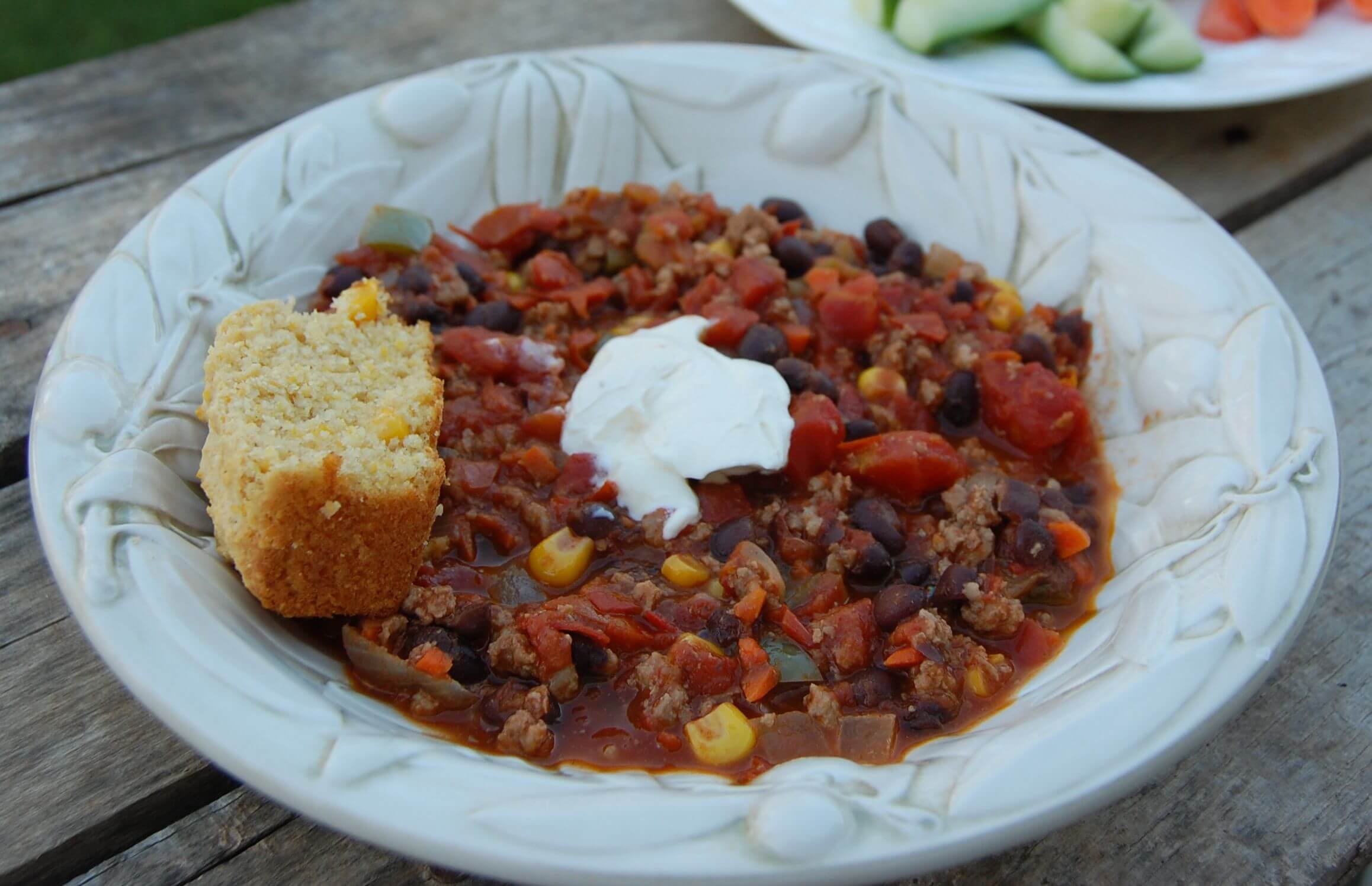 Homemade chili in a bowl with a side of cornbread. 