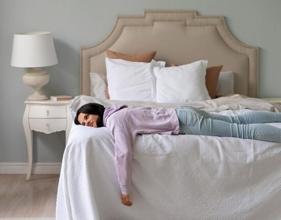 A women wearing pink cloths lying on bed