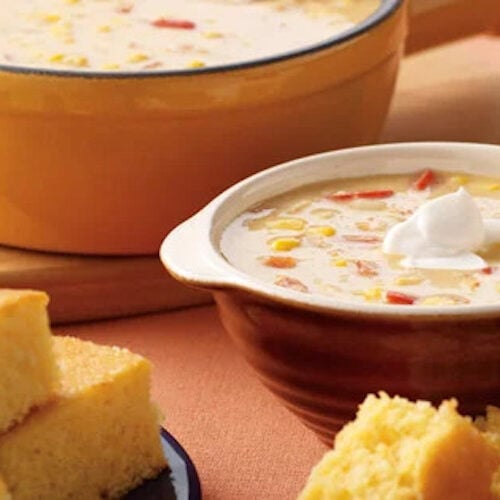 Corn chowder in a bowl with a side of corn bread