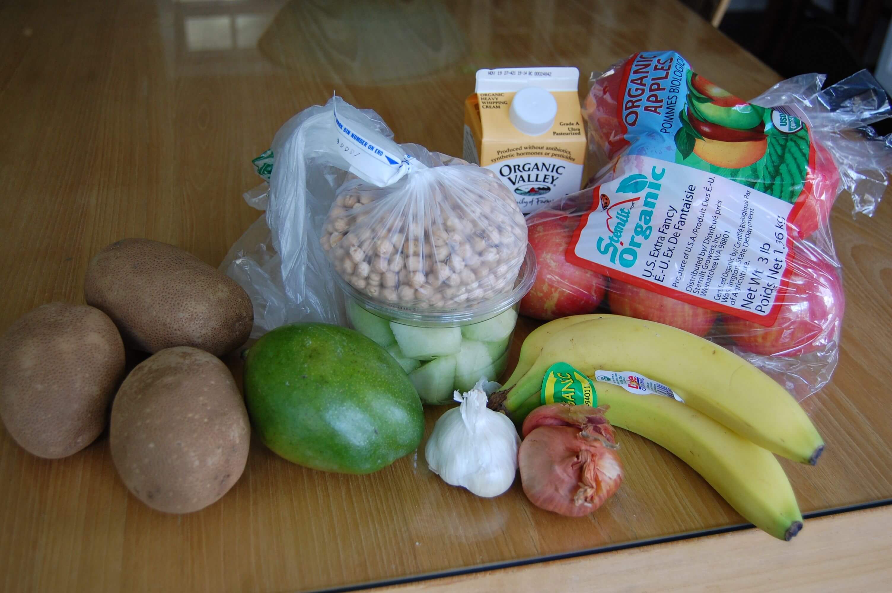 Groceries from Earth Fare that include fresh produce, beans, and heavy cream. 