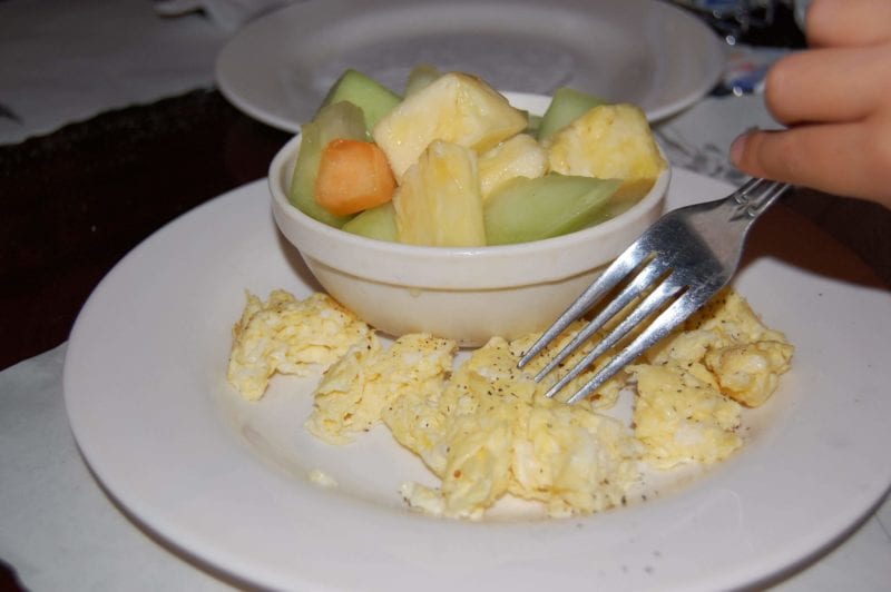 Scrambled eggs and a side of fruit. 