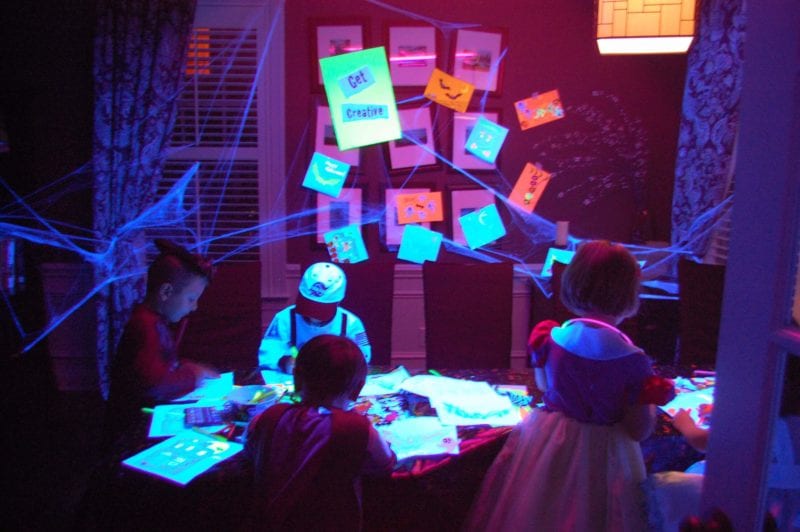 Inside of a house decorated for Halloween with kids dressed in costumes. 