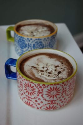 Two decorative cups of homemade mocha hot chocolate.