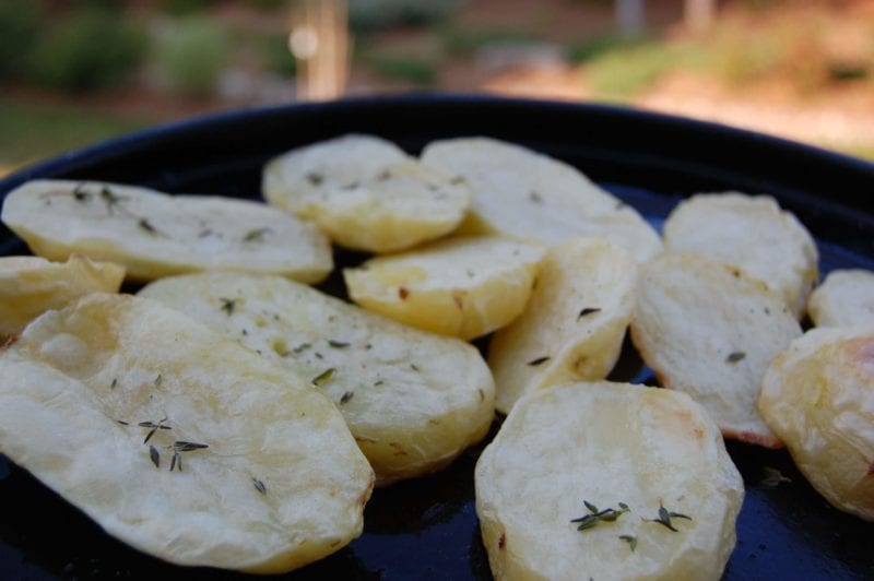 Oven-roasted potatoes sprinkled with thyme on a plate. 
