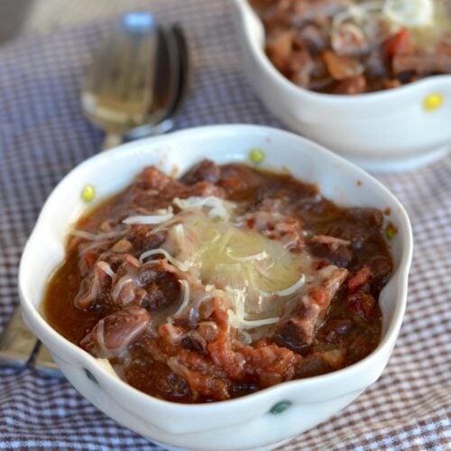 slow cooker steak chili with cheese in a small bowl