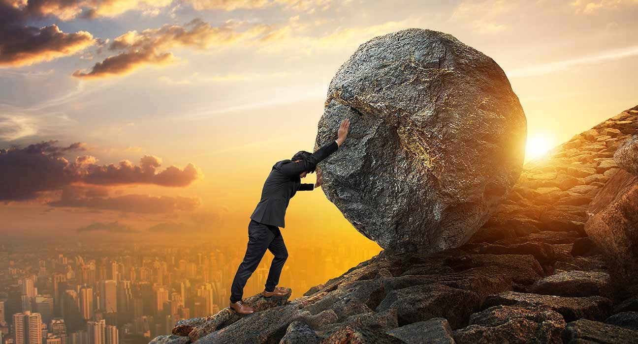 a man pushing a big stone
