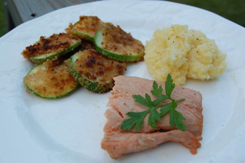 Salmon, breaded zucchini, and mashed potatoes on a plate. 